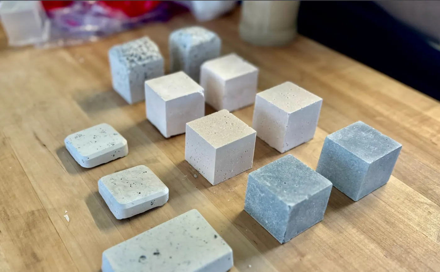 Pale geopolymer cubes on a wooden work surface