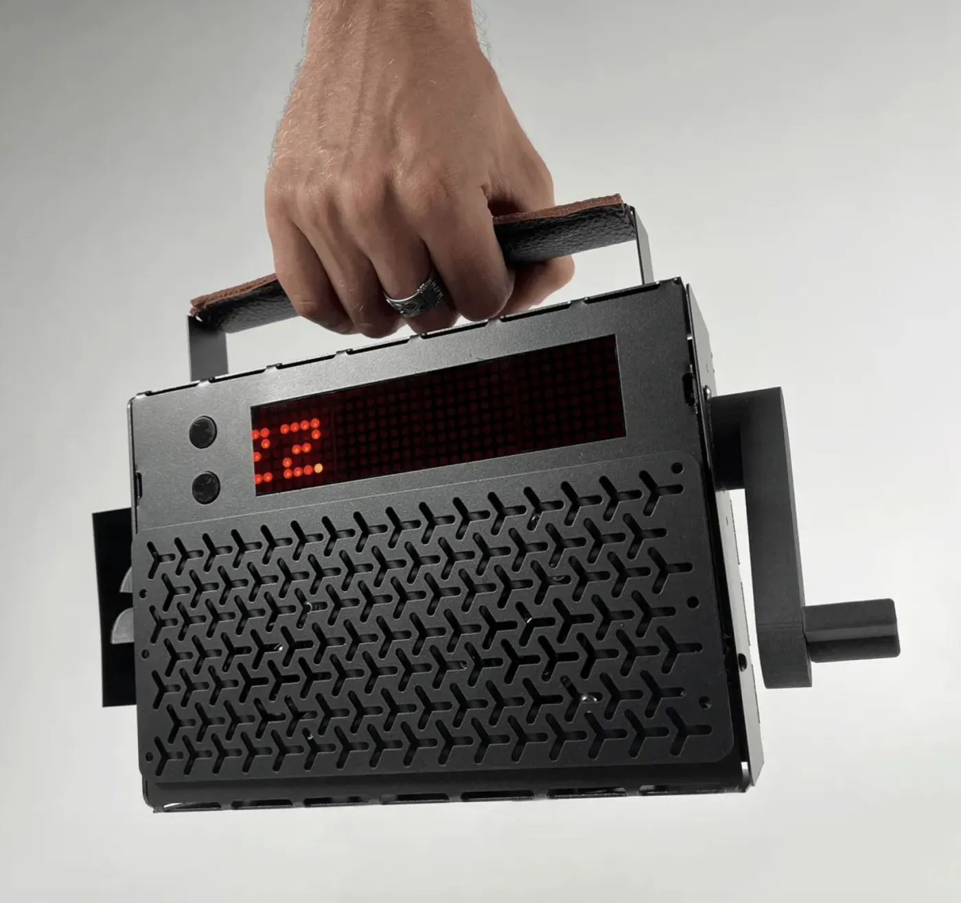 Handheld unit with a textured grip, a small screen and a crank