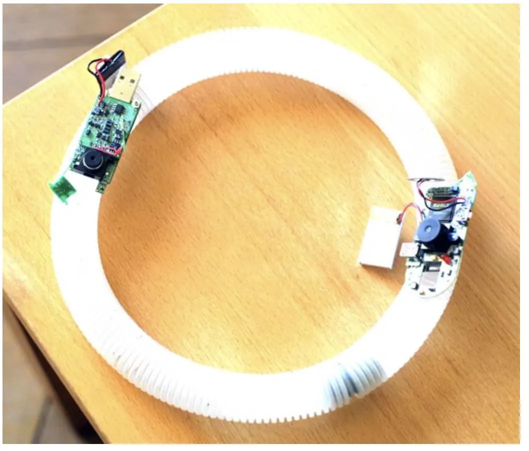 A white ring-shaped device on wood, with its electronic components